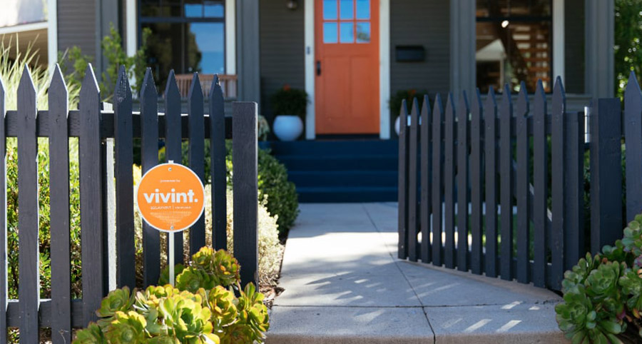 vivint signage in the front yard next to a black picket fence